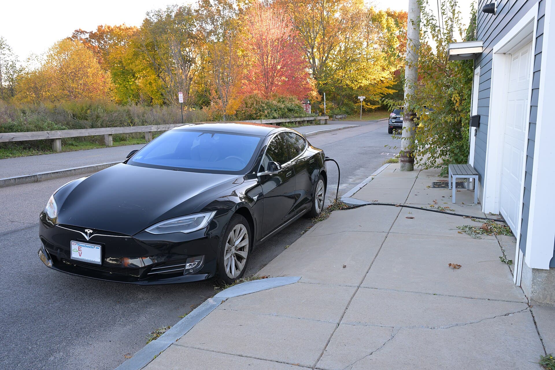 Voiture électrique en charge devant une maison grâce à une installation domestique